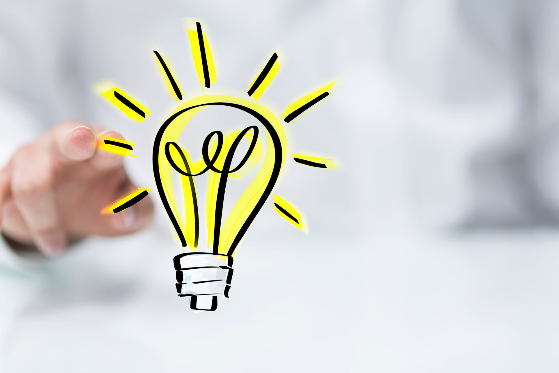 Leuchtende Ideen für nachhaltige Energieberatung: Inspiration im Fokus Gezeichnete leuchtende gelbe Glühbirne, von hinten zeigt eine Hand darauf.